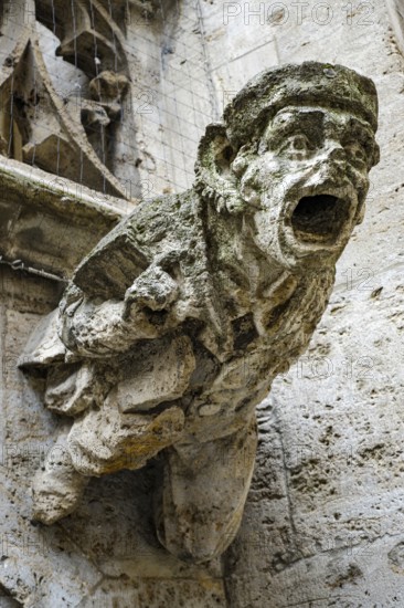 Sculpture of a male figure as a gargoyle, neo-Gothic architectural detail in the inner courtyard of the town hall in Munich, Bavaria, Germany