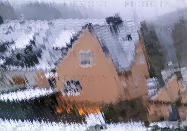Continuous sleet on a window pane with an unclear view of a house in winter, Witten, North Rhine-Westphalia, Germany