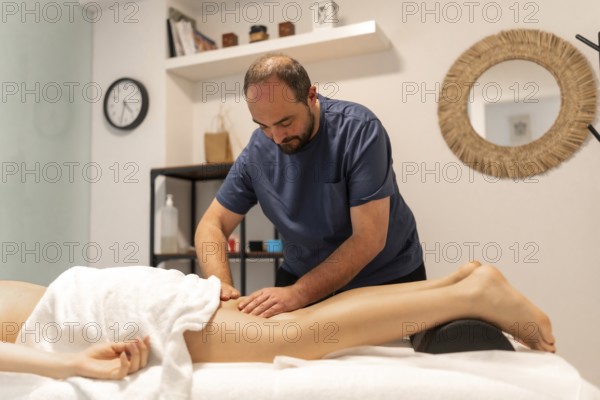 Masseuse working on a client's leg, providing deep tissue therapy for relaxation and muscle recovery in a professional spa or physiotherapy clinic setting
