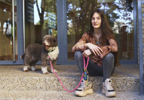 A young woman sits on steps next to a dog with a pink leash, enjoying a sunny day. The scene captures a moment of companionship and relaxation outdoors