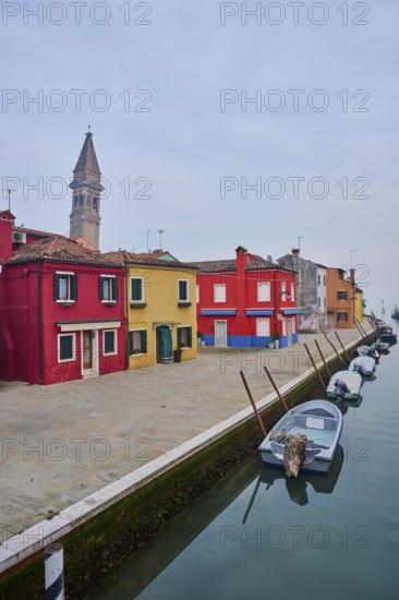 Colorful houses beside the waterway at 'Fondamenta di Pizzo' with boats lying in the water on the island of Burano, Italy