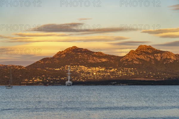 View of Lumio, sailing cruise ship Wind Spirit and the mountains at Calvi Bay, Balagne, Corsica, France