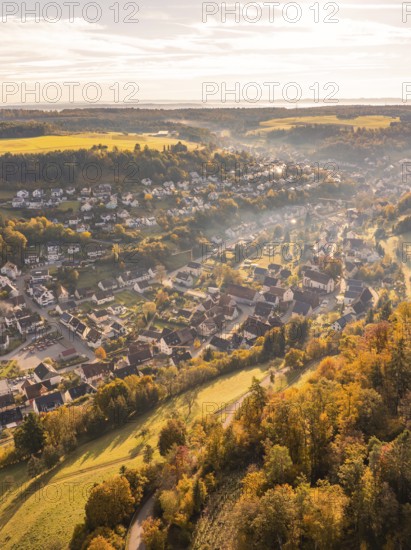 Aerial view of a village in autumnal colours with hills and trees at sunset, Sulz Calw, Black Forest, Germany