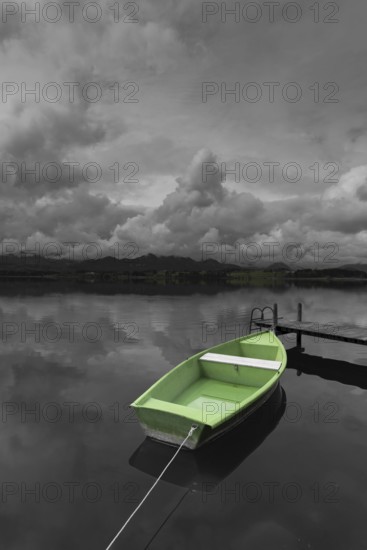 Storm clouds at sunset, a green rowing boat lashed to the wooden jetty, Hopfensee, Hopfen am See, near Füssen, Ostallgäu, Allgäu, Bavaria, Germany