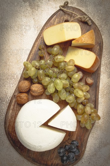 Georgian cheese, Imeretian and smoked suluguni, grapes, nuts, on a cutting board, Georgian cuisine, no people