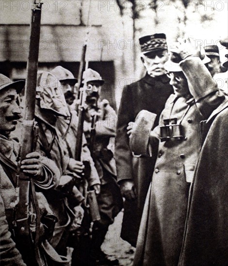 Première Guerre Mondiale. Sur le front de Verdun, le prince Alexandre de Serbie essayant le casque d'un soldat