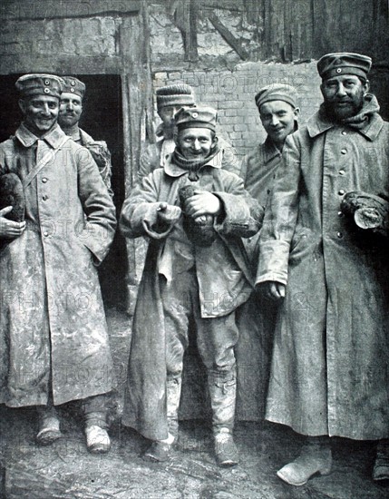 World War I. German prisoners smiling, because they have just received loaves of French bread