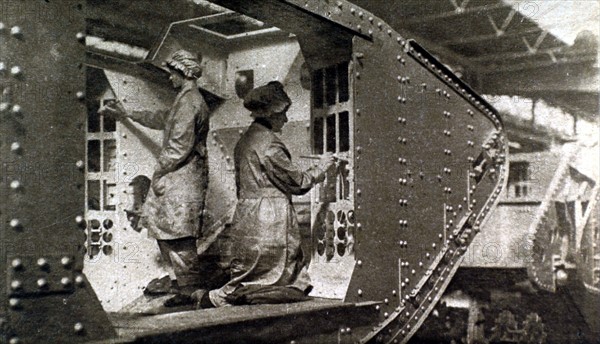 Première Guerre Mondiale. En Angleterre, des femmes peignant l'intérieur d'un tank