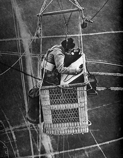 Première Guerre Mondiale. L'observateur d'un ballon captif dit "Saucisse" téléphonant ses observations et vérifiant les attaches de son parachute