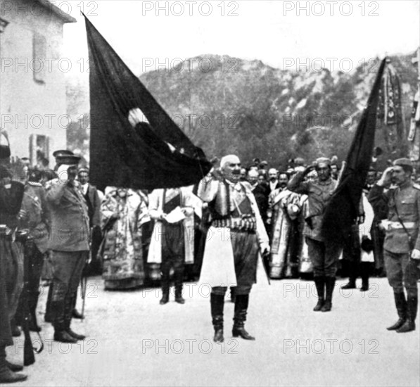 Les clefs de Scutari dans une main, le roi Nicolas du Monténégro, déploie de l'autre, devant ses sujets, un drapeau pris aux Turcs (1913)