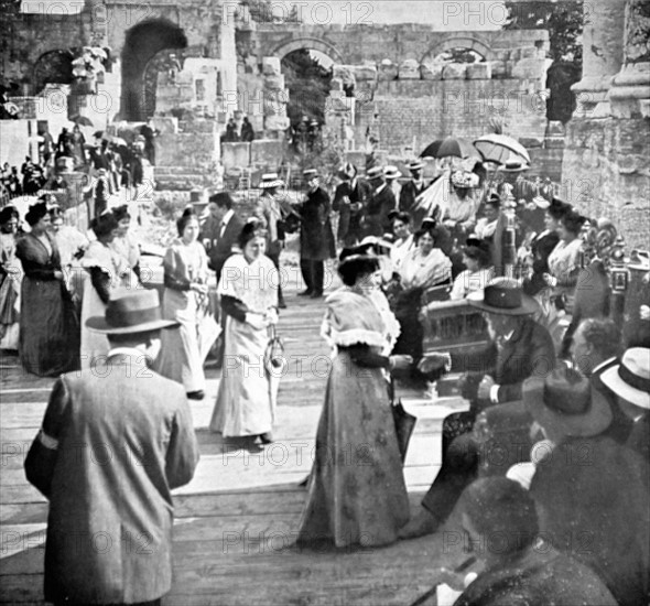 Virginal festivities in Arles. At the Roman theater, young Arlesian women parade before Mistral and hail him (1913)