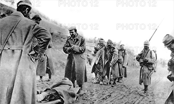 World War I. In Champagne, after the battle, able-bodied prisoners help wounded French soldiers reach an ambulance (1915)