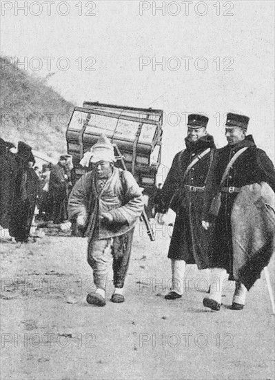 Korea : ; Japanese officers with a Korean porter