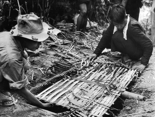 Guerilleros Sud-Vietnamens posant un piège pour l'ennemi