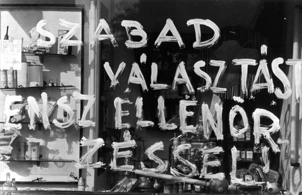 1956, Budapest, a slogan on a shop window reads: "A free election under the control of..."