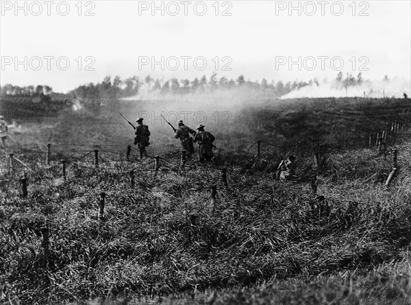 Soldiers from the American infantry advancing behind a tank near Beauquesnes