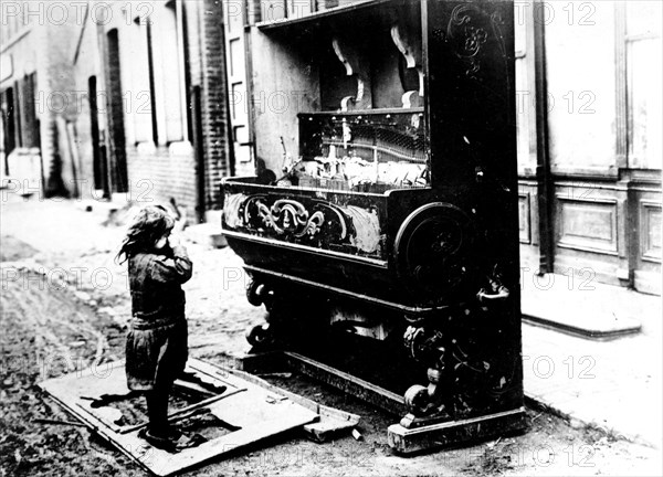 Après le bombardement, enfant pleurant devant son piano détruit