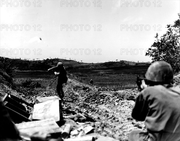 The Pacific War in Okinawa: American Marine throwing a grenade towards the Japanese lines