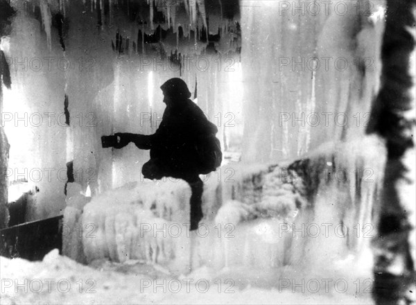 Australian soldier getting an "ice drink" under a frozen tank