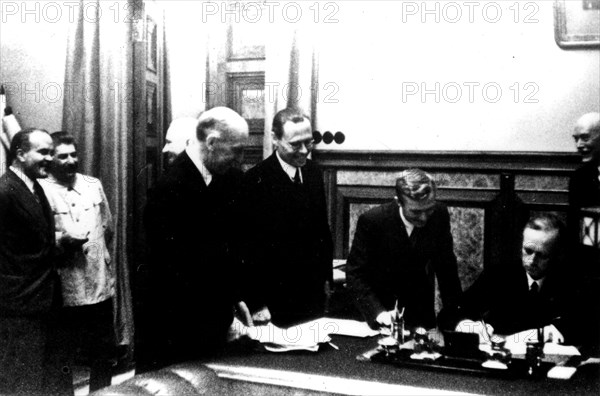 Signing of the Germano-Soviet Non-Agression Pact in Moscow. Ribbentrop signs. (Also seen: Stalin and Molotov)