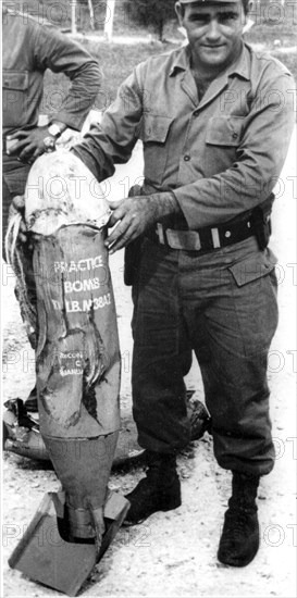 Landing at the bay of Pigs. Cuban soldier showing an American bomb dropped on Cuba.