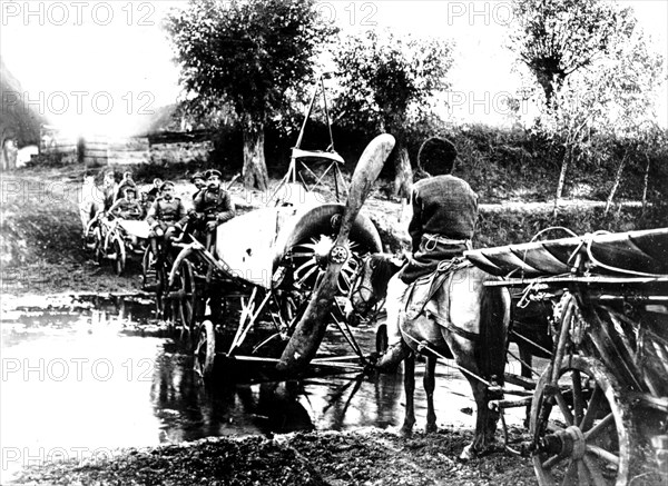 Carts carrying a plane and crossing a brook