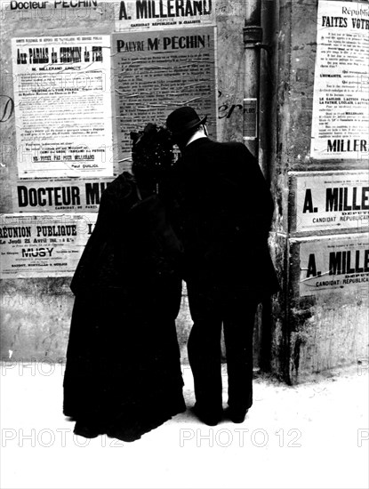 Elections: Couple reading a poster