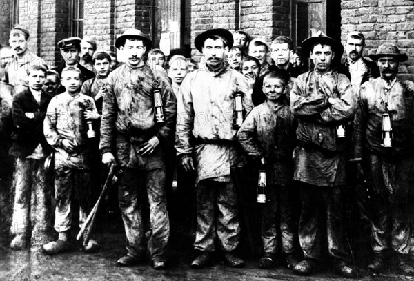 Groupe d'enfants et d'hommes travaillant dans la mine de Denain