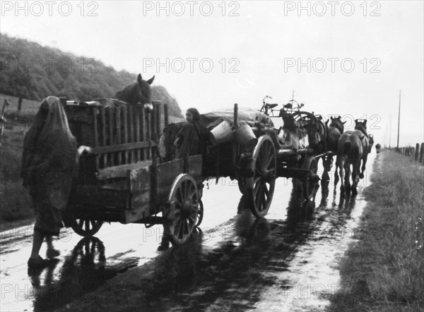 On a rainy day, exodus of French refugees who leave their town and houses