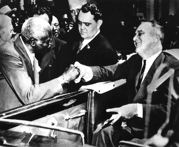 At Tuskegee institute, a black school founded by Booker T. Washington, Roosevelt is shaking hands with professor G.W. Carver, an eminent scientist in the field of agriculture. c.1935