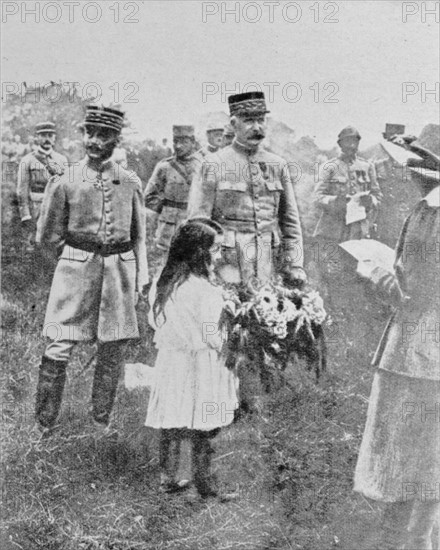 Le général Pétain recevant des fleurs d'une petite fille le 14 juillet, à Lagny
