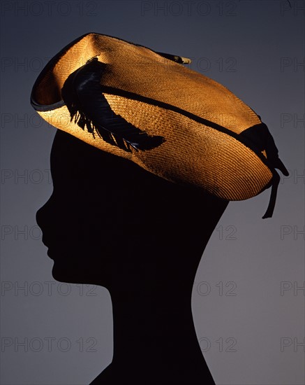 Oriental straw hat with gros-grain ribbon trim and eagle feather