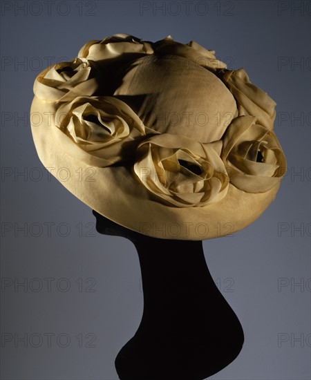 Yellow synthetic chiffon hat with flower appliqué in the same material with black pistils