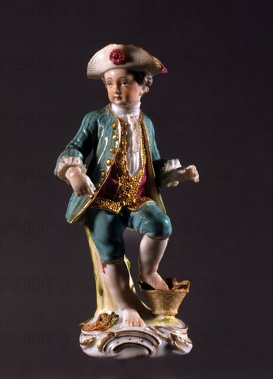 Figurine d'un garçon avec un panier de légumes.