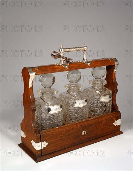 Oak tantalus with three bottles of grave crystal.
