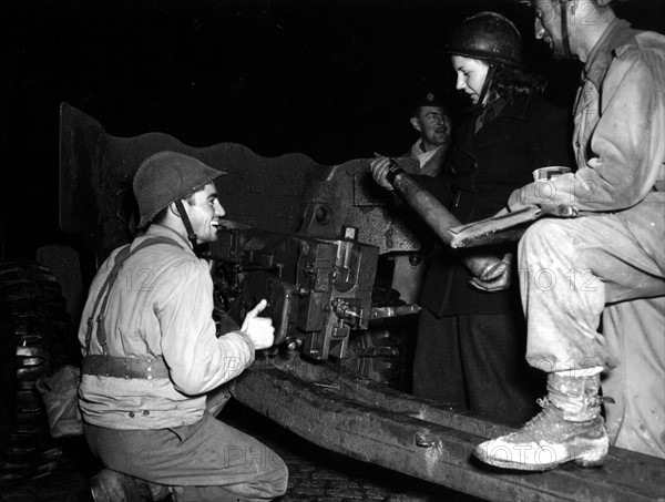 Une jeune femme des Forces françaises de l'intérieur charge un canon dans la région de Belfort. (24 novembre 1944)