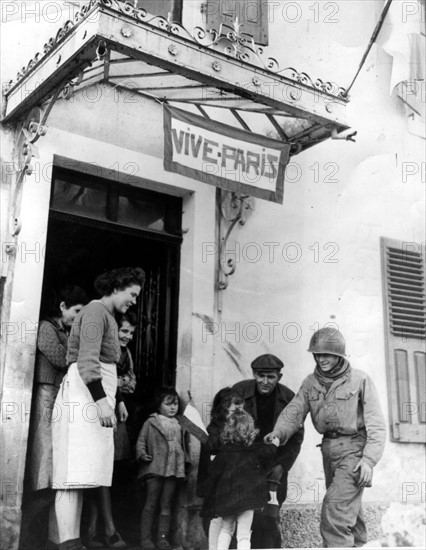 Des civils libérés accueillent un soldat français à  Champey (Est de la France). novembre 1944