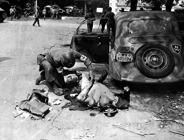 A soldier of the U.S Army Medical Corps aids a German officer near Chartres (France) August 1944