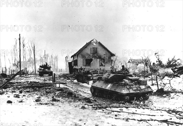 French drive tank destroyers through war-ravaged Bettenhoffen (France) January 1945