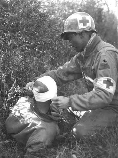 A U.S medical man bandages the head of wounded soldier in Bremencourt area (France) September 12, 1944