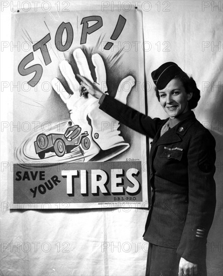 Femme du W.A.C montrant une affiche publicitaire pour des pneus à Marseille (27 mars 1945)