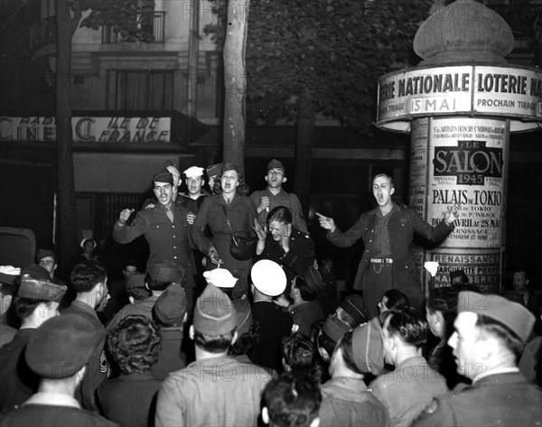 Des chants d'allégresse résonnent dans les rues de Paris.
(8 mai 1945)