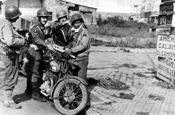 A Beauvais, des Britanniques indiquent le chemin à des soldats américains.
(31 août 1944)