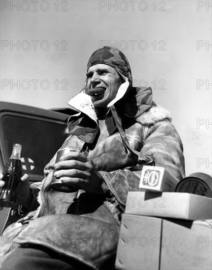 Un soldat américain, ancien prisonnier de guerre, mange des beignets et boit du coca-cola au Havre.
(3 avril 1945)