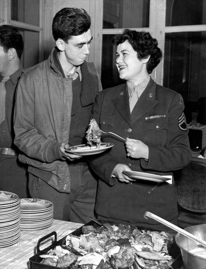 Un soldat américain et une femme du corps d'armée féminin U.S., lors d'un dîner organisé pour Thanksgiving, à Paris.
(23 novembre 1944)