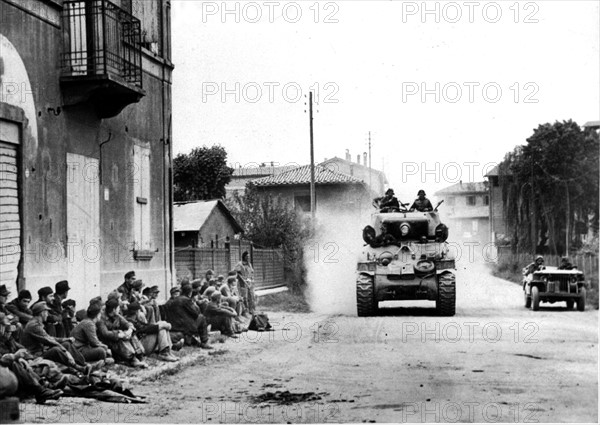 Un char sud-africain passe devant un groupe de prisonniers allemands à Bologne, en Italie.
(23 avril 1945)