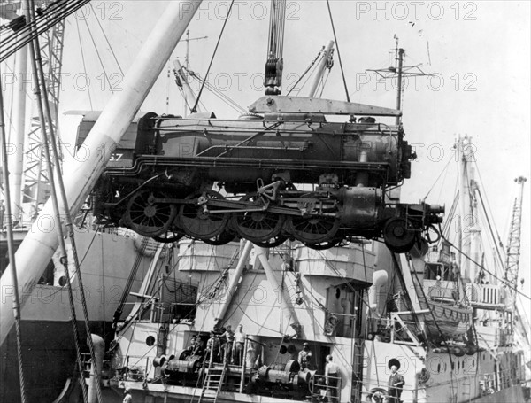A heavy American freight engine is swung ashore at Cherbourg harbour in France, Autumn 1944
