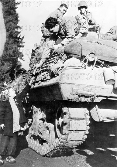 A 1st French Army tank crew gives a chocolate bar to a French girl in Couthenans area, November 1944