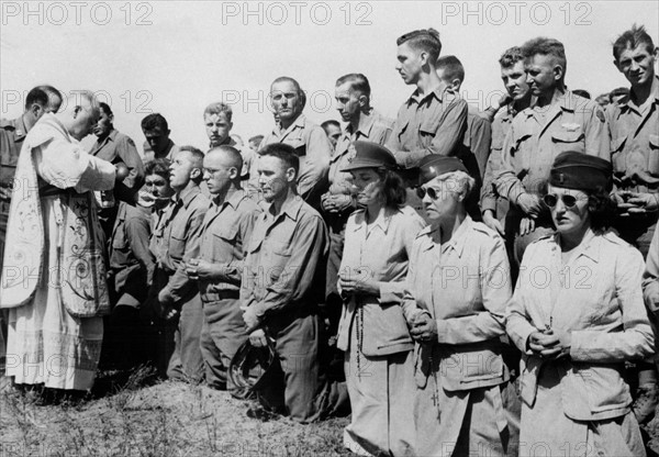 Un vicaire militaire donne l'eucharistie sur le front italien.
 (Eté 1944)