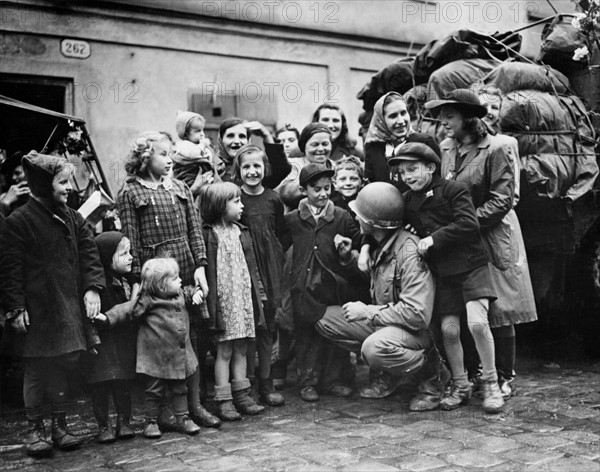 Des enfants tchèques entourent un soldat américain à Pilsen.
(6 mai 1945)